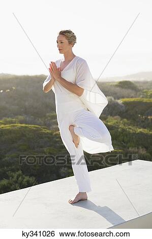 Mid adult woman practicing yoga View Large Photo Image Stock Photograph - Mid adult woman practicing yoga. Fotosearch