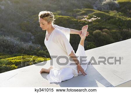 Mid adult woman practicing yoga exercise at terrace View Large Photo Image Stock Photography - Mid adult woman practicing yoga exercise at terrace. Fotosearch