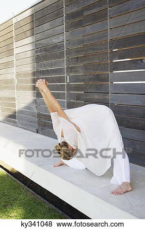 Mid adult woman stretching her arms View Large Photo Image Stock Photo - Mid adult woman stretching her arms. Fotosearch