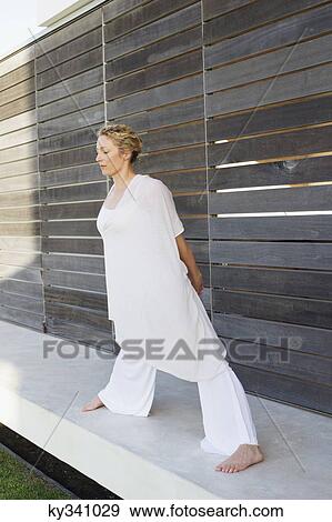Mid adult woman stretching her legs View Large Photo Image Stock Photo - Mid adult woman stretching her legs. Fotosearch