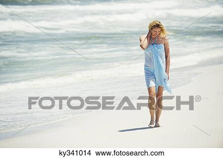 Mid adult woman walking on the beach View Large Photo Image Picture - Mid adult woman walking on the beach. Fotosearch
