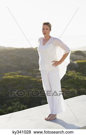 Portrait of a mid adult woman standing on a terrace View Large Photo Image Stock Photo - Portrait of a mid adult woman standing on a terrace. Fotosearch