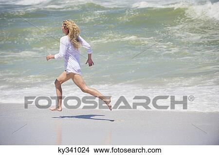 Side profile of a beautiful woman running on the beach View Large Photo Image Picture - Side profile of a beautiful woman running on the beach. Fotosearch