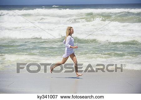Side profile of a beautiful woman running on the beach View Large Photo Image Stock Photo - Side profile of a beautiful woman running on the beach. Fotosearch