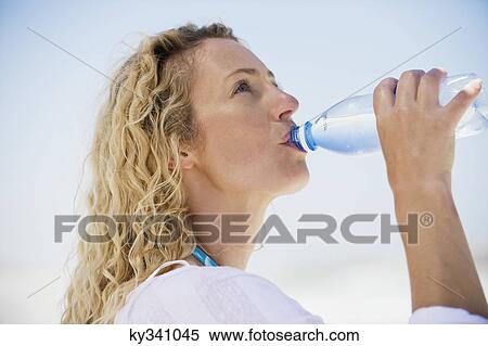 Side profile of a beautiful woman drinking purified water View Large Photo Image Stock Photography - Side profile of a beautiful woman drinking purified water. Fotosearch
