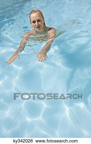 Beautiful woman swimming in a pool View Large Photo Image Stock Photograph - Beautiful woman swimming in a pool. Fotosearch