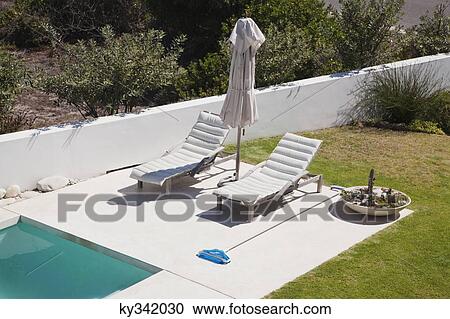 High angle view of lounge chairs at poolside View Large Photo Image Stock Image - High angle view of lounge chairs at poolside. Fotosearch