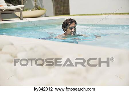 Mid adult man swimming in pool at terrace View Large Photo Image Stock Image - Mid adult man swimming in pool at terrace. Fotosearch