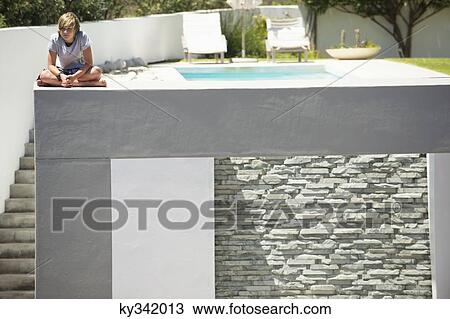 Teenage boy sitting at the edge of a terrace View Large Photo Image Stock Image - Teenage boy sitting at the edge of a terrace. Fotosearch
