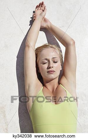 Stock Photo - Woman sunbathing at poolside. Fotosearch