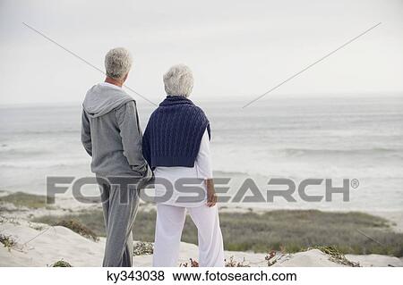 Stock Photo - Rear view of a senior couple looking at the sea. Fotosearch