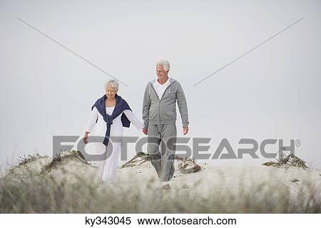 Senior couple walking on the beach View Large Photo Image Stock Photography - Senior couple walking on the beach. Fotosearch