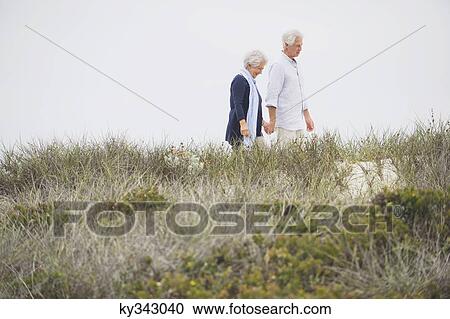 Senior couple walking on the beach with holding hands of each other View Large Photo Image Stock Image - Senior couple walking on the beach with holding hands of each other. Fotosearch