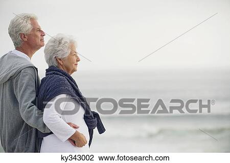 Stock Image - Side profile of a senior couple looking at the sea. Fotosearch