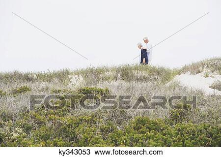 Side profile of a senior couple walking on the beach View Large Photo Image Stock Image - Side profile of a senior couple walking on the beach. Fotosearch