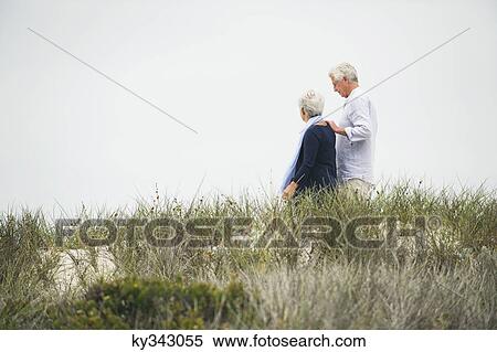Side profile of a senior couple walking on the beach View Large Photo Image Stock Photography - Side profile of a senior couple walking on the beach. Fotosearch