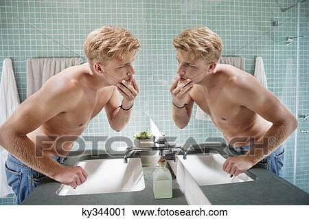Man looking at himself in mirror View Large Photo Image Stock Image - Man looking at himself in mirror. Fotosearch