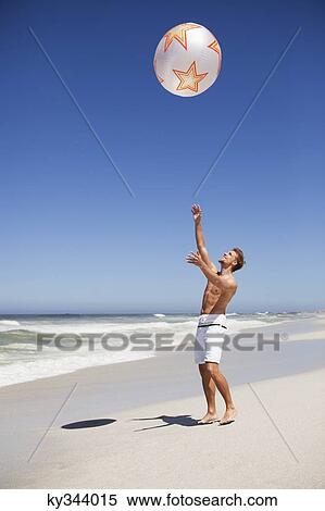 Stock Photography - Man playing with beach ball. Fotosearch