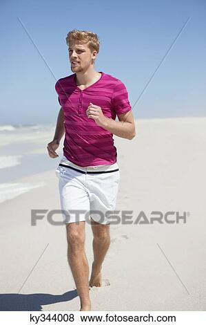 Stock Photo - Man running on the beach. Fotosearch