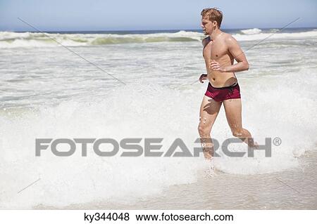 Stock Photo - Man running on the beach. Fotosearch