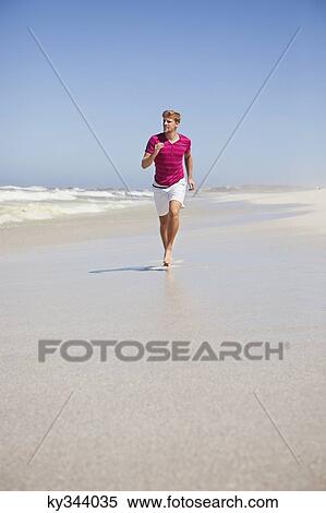 Stock Photography - Man running on the beach. Fotosearch