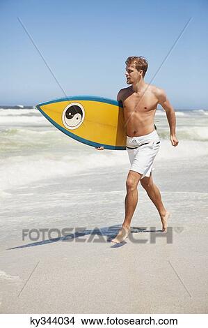 Man running on the beach with surfboard View Large Photo Image Picture - Man running on the beach with surfboard. Fotosearch
