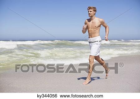 Man running shirtless on the beach View Large Photo Image Stock Photograph - Man running shirtless on the beach. Fotosearch
