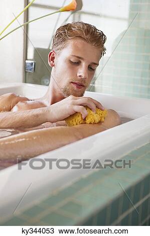 Man scrubbing his body in the bathtub View Large Photo Image Stock Image - Man scrubbing his body in the bathtub. Fotosearch