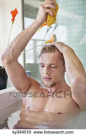 Man squeezing a bath sponge over his head View Large Photo Image Stock Image - Man squeezing a bath sponge over his head. Fotosearch