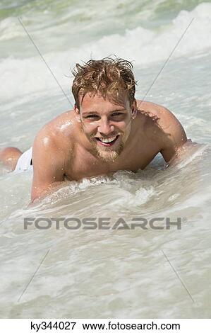 Portrait of a young man lying on water View Large Photo Image Stock Photo - Portrait of a young man lying on water. Fotosearch