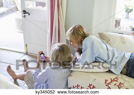 Children using mobile phone at house View Large Photo Image Stock Image - Children using mobile phone at house. Fotosearch