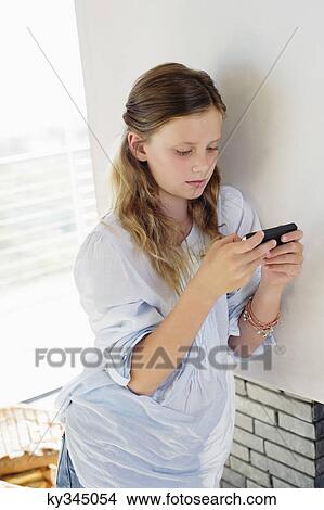 Girl playing with a handheld video game at home View Large Photo Image Picture - Girl playing with a handheld video game at home. Fotosearch