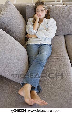 High angle view of a girl lying on a couch View Large Photo Image Picture - High angle view of a girl lying on a couch. Fotosearch
