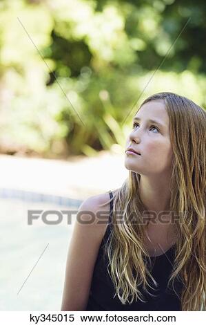 Stock Photography - Little girl sitting by the swimming pool and thinking. Fotosearch