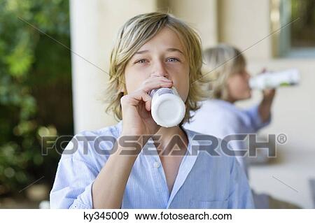 Portrait of a little boy drinking milk with brother in the background View Large Photo Image Stock Photo - Portrait of a little boy drinking milk with brother in the background. Fotosearch
