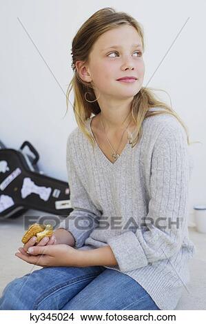 Side profile of a beautiful girl eating cookies View Large Photo Image Picture - Side profile of a beautiful girl eating cookies. Fotosearch