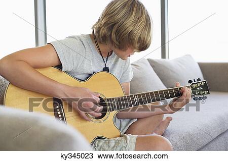 Teenage boy playing guitar at home View Large Photo Image Stock Image - Teenage boy playing guitar at home. Fotosearch