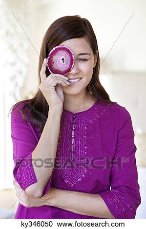 Beautiful young woman looking through the hole in an object View Large Photo Image Stock Image - Beautiful young woman looking through the hole in an object. Fotosearch