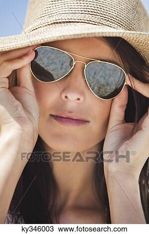 Close-up of a woman wearing sunglasses View Large Photo Image Stock Image - Close-up of a woman wearing sunglasses. Fotosearch