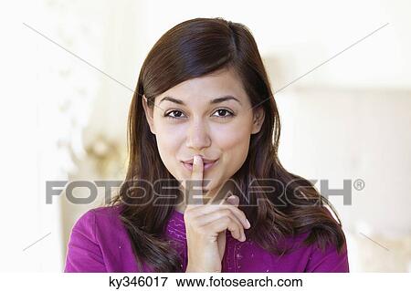 Portrait of a woman showing keep silence gesture View Large Photo Image Stock Photo - Portrait of a woman showing keep silence gesture. Fotosearch