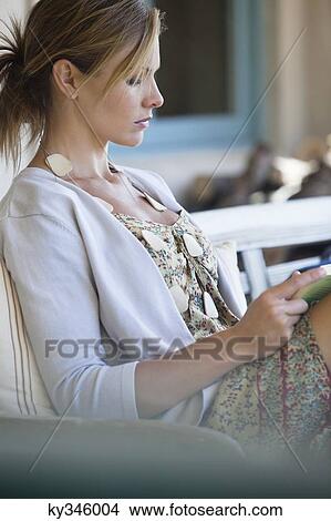 Picture - Side profile of a beautiful young woman reading a book. Fotosearch