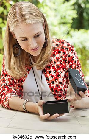 Woman opening a model home box and smiling View Large Photo Image Stock Photography - Woman opening a model home box and smiling. Fotosearch