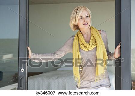 Woman standing at door and smiling View Large Photo Image Stock Photo - Woman standing at door and smiling. Fotosearch