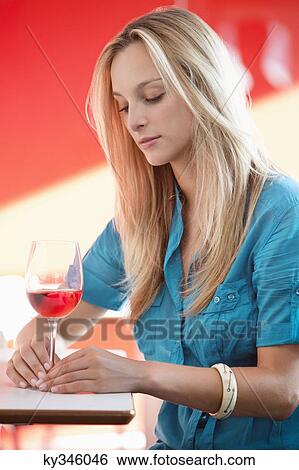 Young woman having red wine and thinking in a bar View Large Photo Image Stock Photograph - Young woman having red wine and thinking in a bar. Fotosearch
