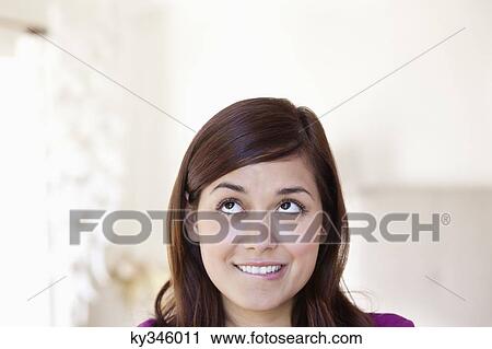Young woman looking away while biting lips View Large Photo Image Stock Image - Young woman looking away while biting lips. Fotosearch