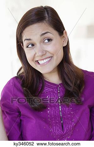 Young woman looking away while biting lips View Large Photo Image Stock Image - Young woman looking away while biting lips. Fotosearch