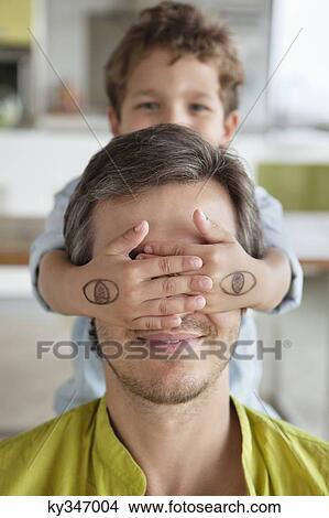 Picture - Boy covering his father's eyes. Fotosearch