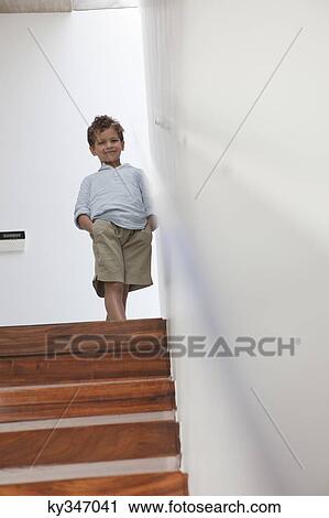 Boy standing on a staircase View Large Photo Image Stock Image - Boy standing on a staircase. Fotosearch