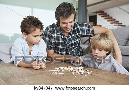 Boys playing pick up sticks with their father View Large Photo Image Stock Photo - Boys playing pick up sticks with their father. Fotosearch