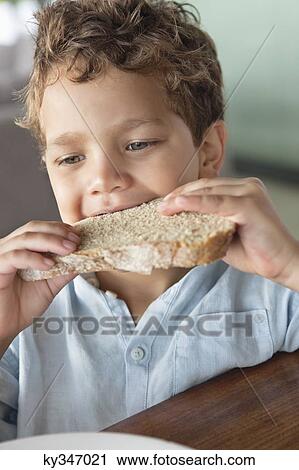 Stock Image - Close-up of a boy eating bread. Fotosearch
